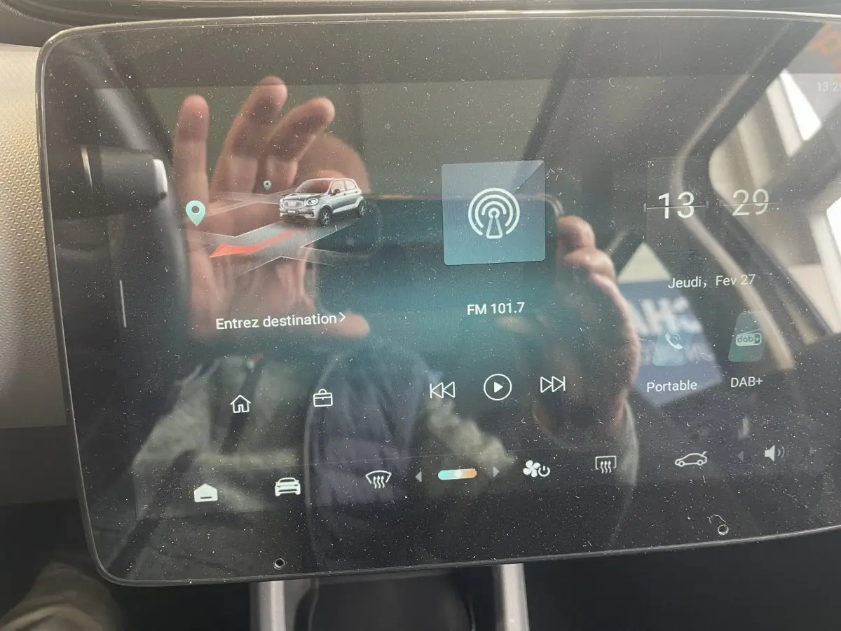 Écran tactile central du tableau de bord du Leapmotor T03 Luxury blanc, affichant navigation et radio FM.