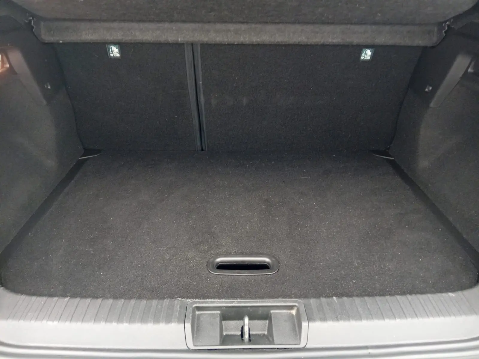 Vue intérieure du coffre vide du Renault Captur 1.3 Mild Hybrid 140 Techno, revêtement noir uniforme.
