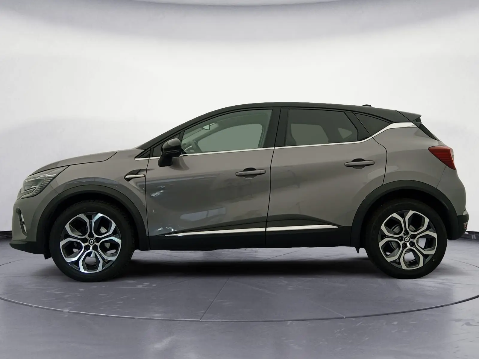 Vue de profil côté gauche du Renault Captur 1.3 Mild Hybrid 140 en gris Cassiopée avec toit noir et jantes alliage 18 pouces.