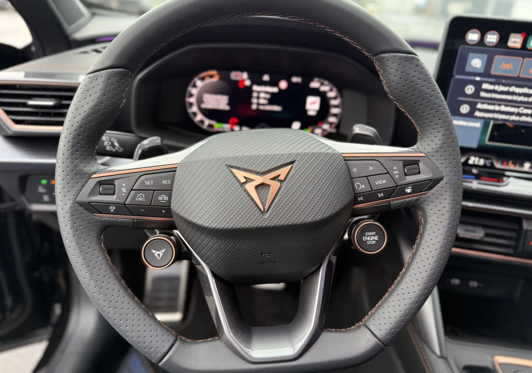 Vue rapprochée du volant perforé noir avec surpiqûres cuivrées et logo CUPRA cuivré du Formentor 1.5 eHybrid 2025.