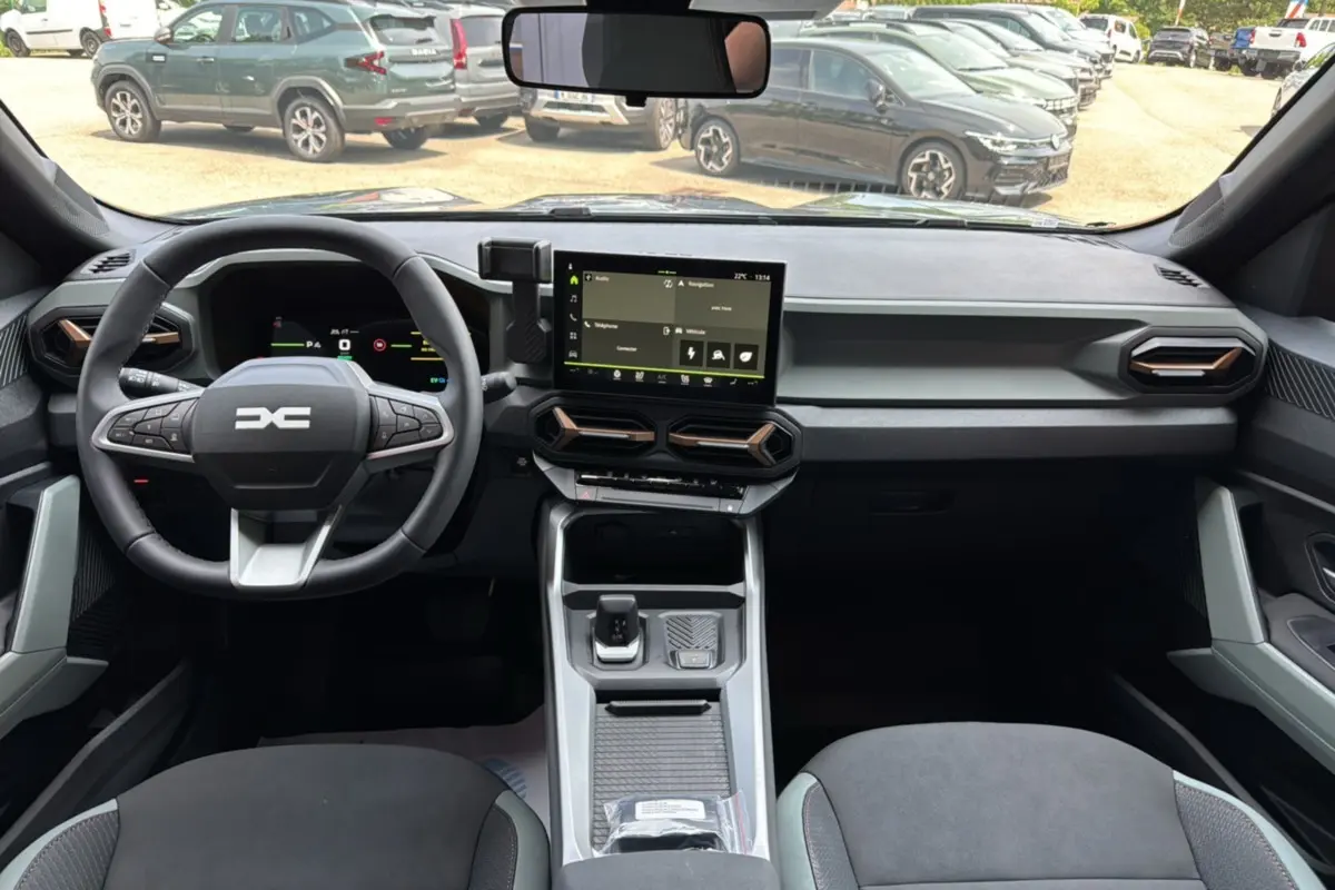 Vue intérieure avant du Dacia Bigster gris schiste, tableau de bord moderne avec écran tactile central et volant multifonction.