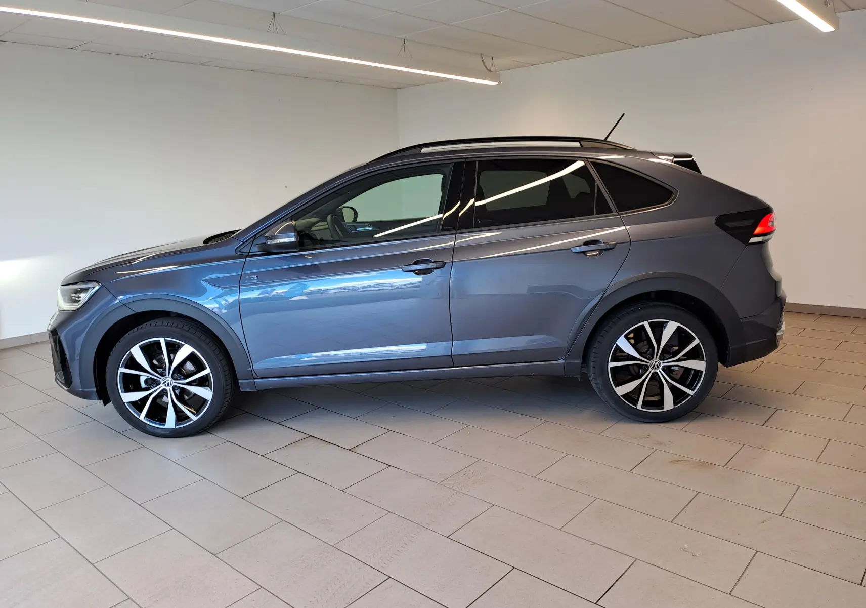 Vue de profil côté gauche du Volkswagen Taigo 1.0 TSI R-Line 2025 en gris cendré métallisé avec jantes alliage 18 pouces.
