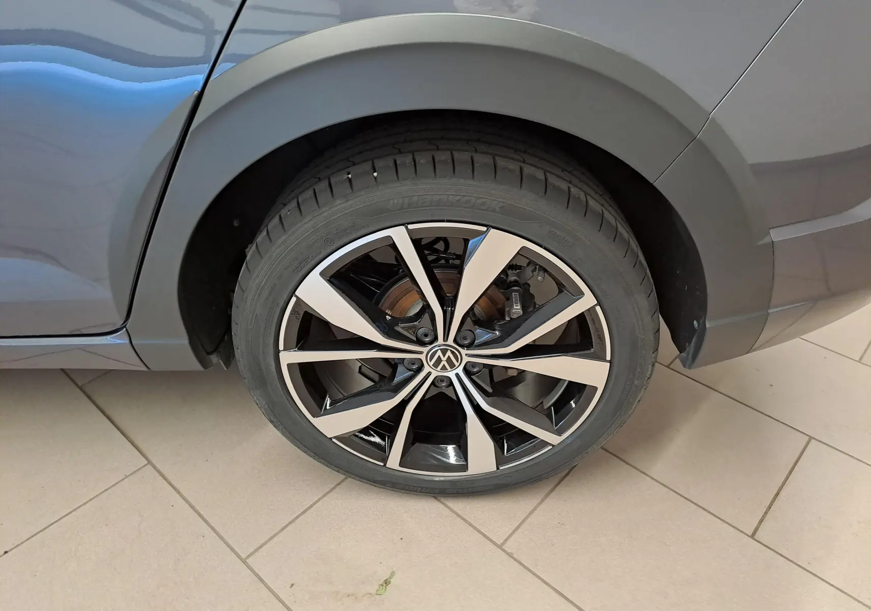 Gros plan sur la roue arrière droite du Volkswagen Taigo gris cendré avec jante alliage noir et argent "Misano" 18 pouces.
