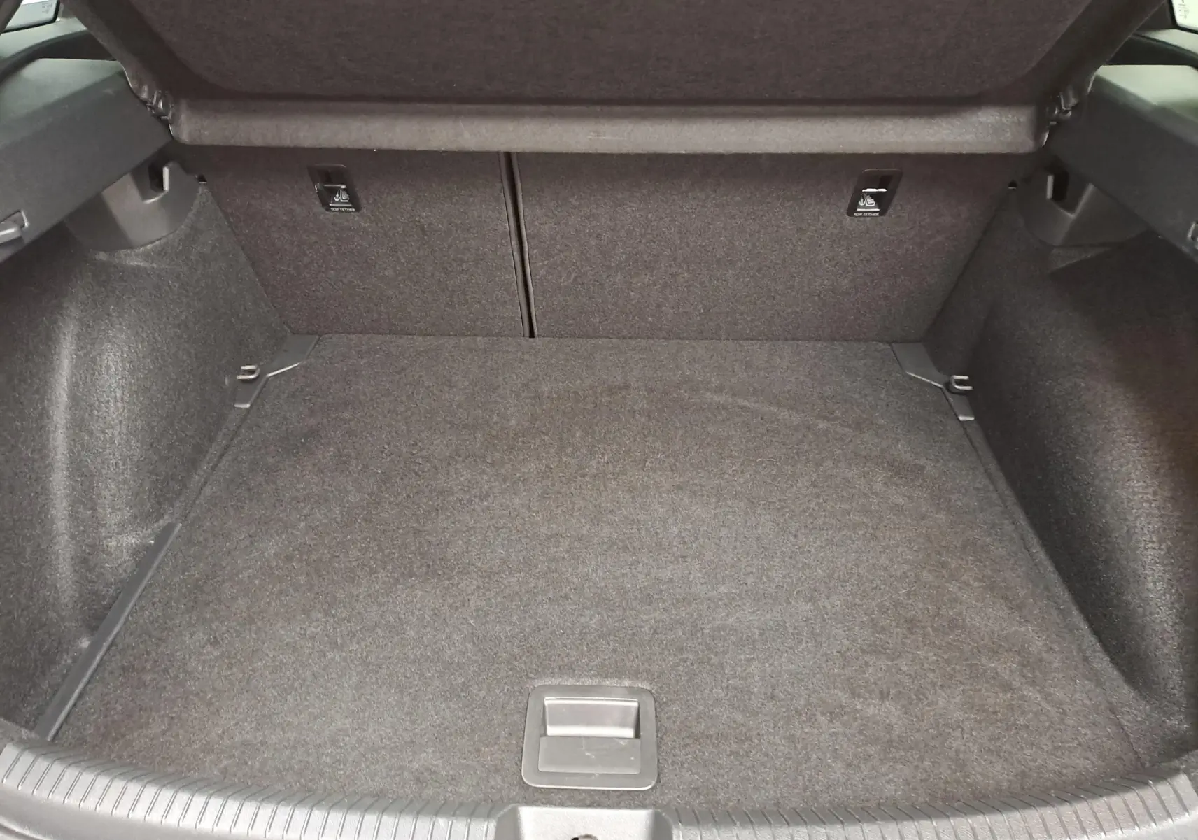 Vue intérieure du coffre spacieux et propre du Volkswagen Taigo 2025, revêtement gris foncé uniforme.