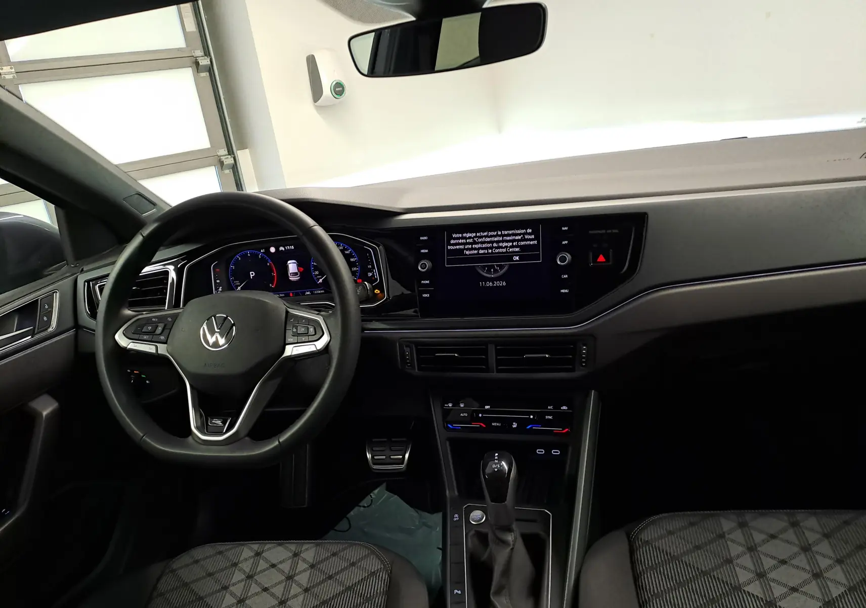 Vue intérieure du tableau de bord et volant du Volkswagen Taigo 1.0 TSI R-Line Edition avec écran digital et sellerie à motifs.
