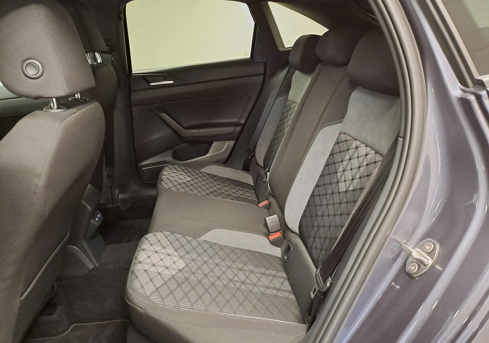 Vue intérieure côté droit des sièges arrière du Volkswagen Taigo gris cendré avec sellerie tissu à motifs géométriques.