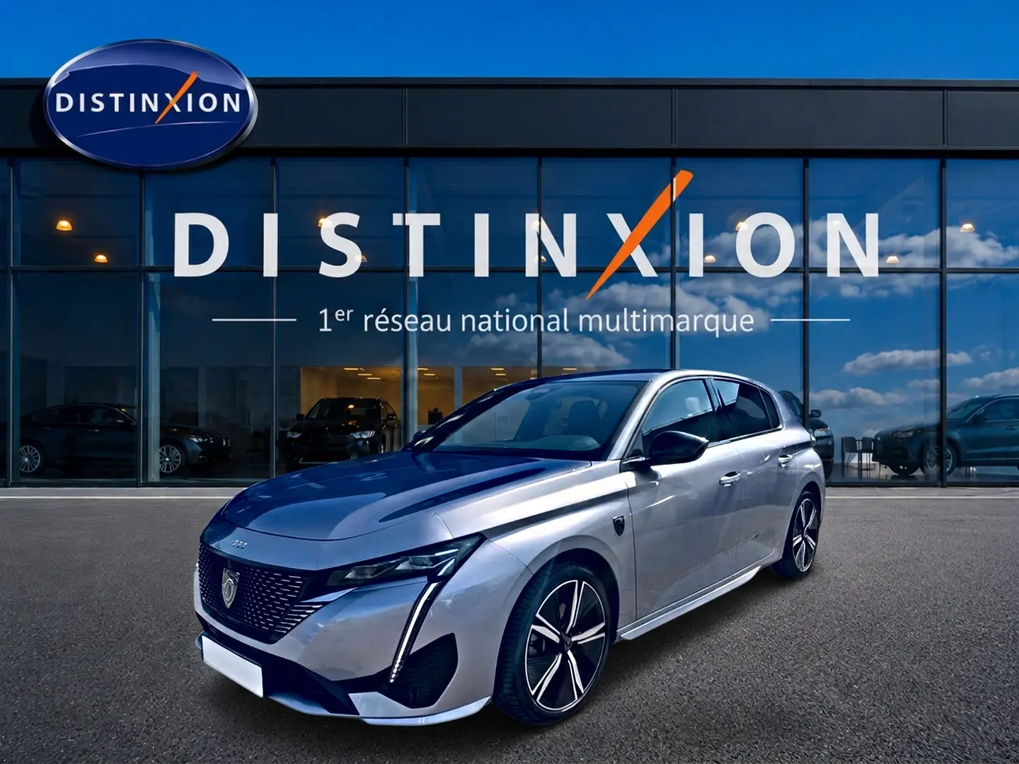 Peugeot 308 1.2 hybrid gris vue 3/4 avant droit, jantes alu et phares LED devant showroom Distinxion.