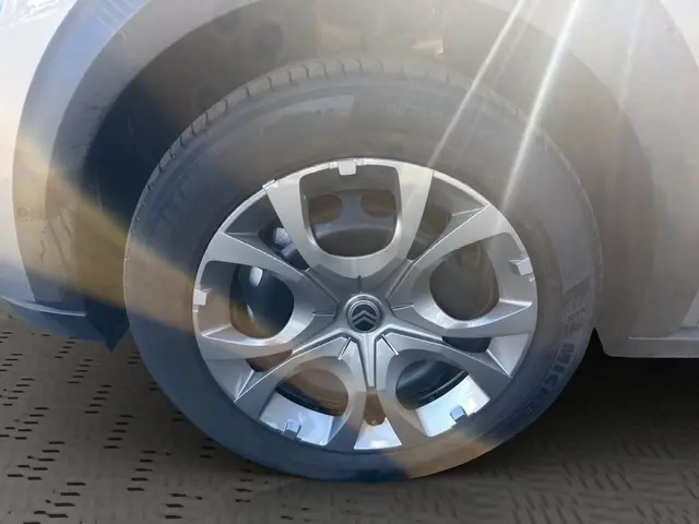 Gros plan sur la roue avant droite d'une Citroën C3 gris foncé avec jante alliage et logo Citroën central.