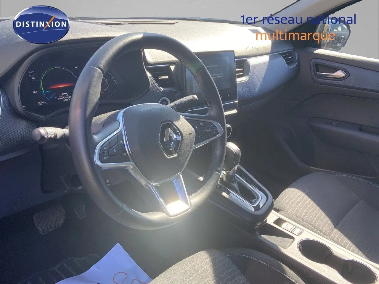 Vue intérieure du poste de conduite du Renault Arkana noir métal 2023, volant multifonction et console centrale avec boîte auto.