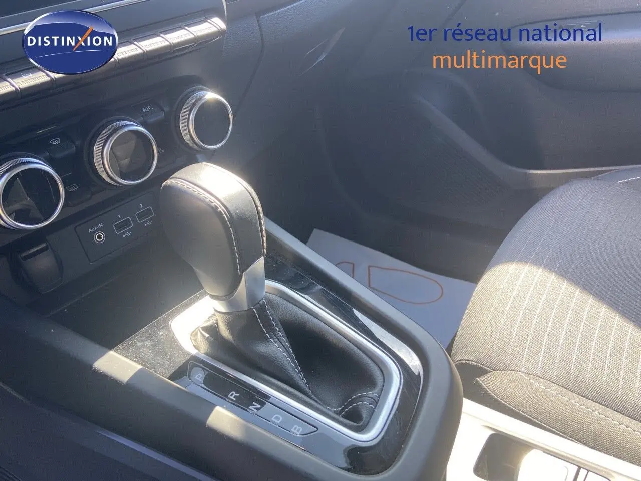 Le levier de vitesse automatique noir et argenté du Renault Arkana 2023, avec la console centrale et sièges en tissu gris.