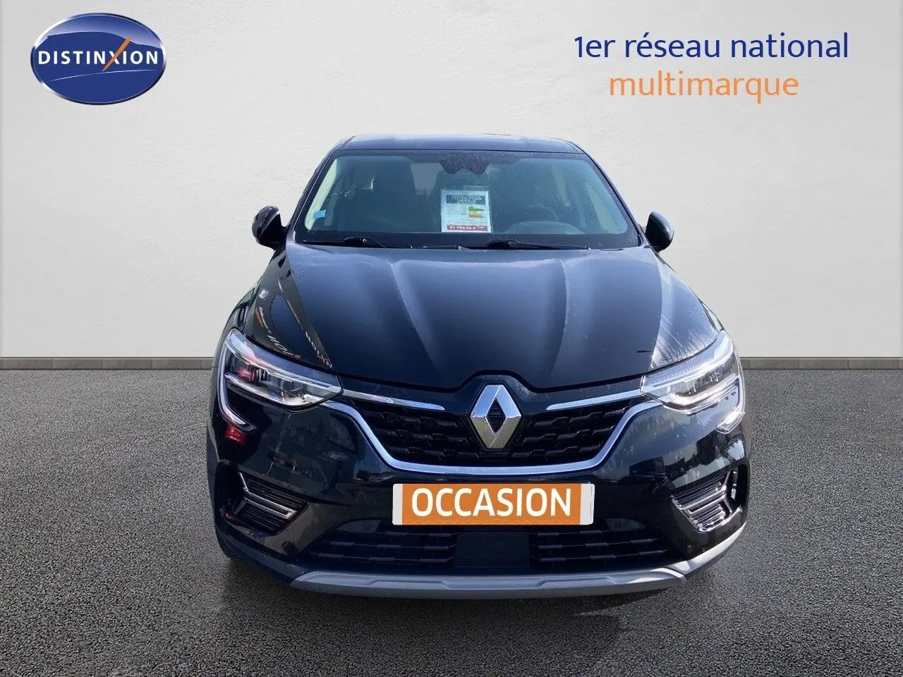 Vue frontale d'un Renault Arkana noir métal 2023 avec éclairage LED et badge distinctif au centre de la calandre.