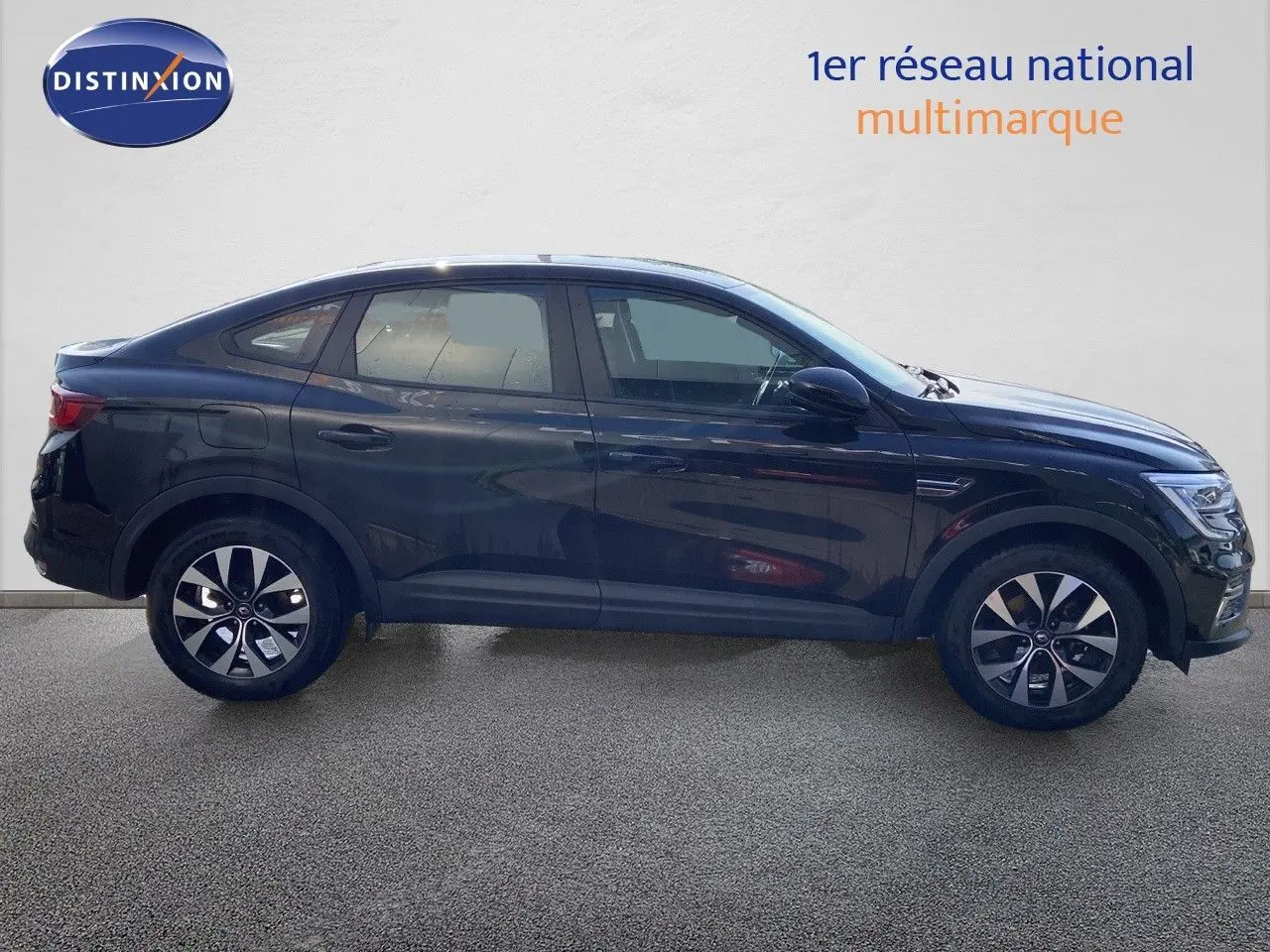 Profil côté gauche d'un Renault Arkana noir métal 2023 avec jantes bi-ton et lignes fluides de SUV coupé.