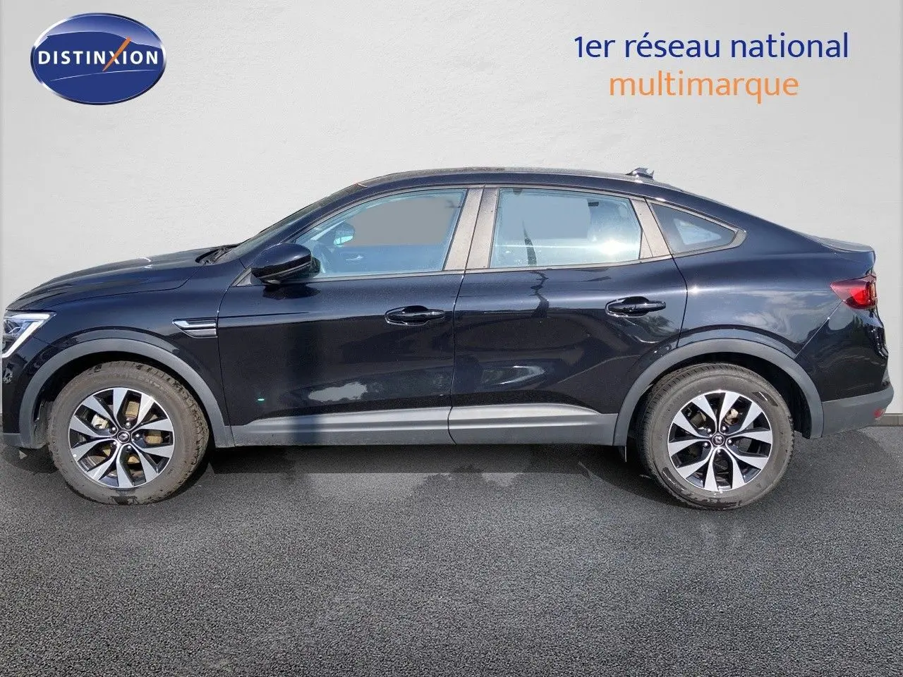 Profil latéral droit d'un Renault Arkana noir métal 2023 avec jantes alliage bicolores et lignes fluides.