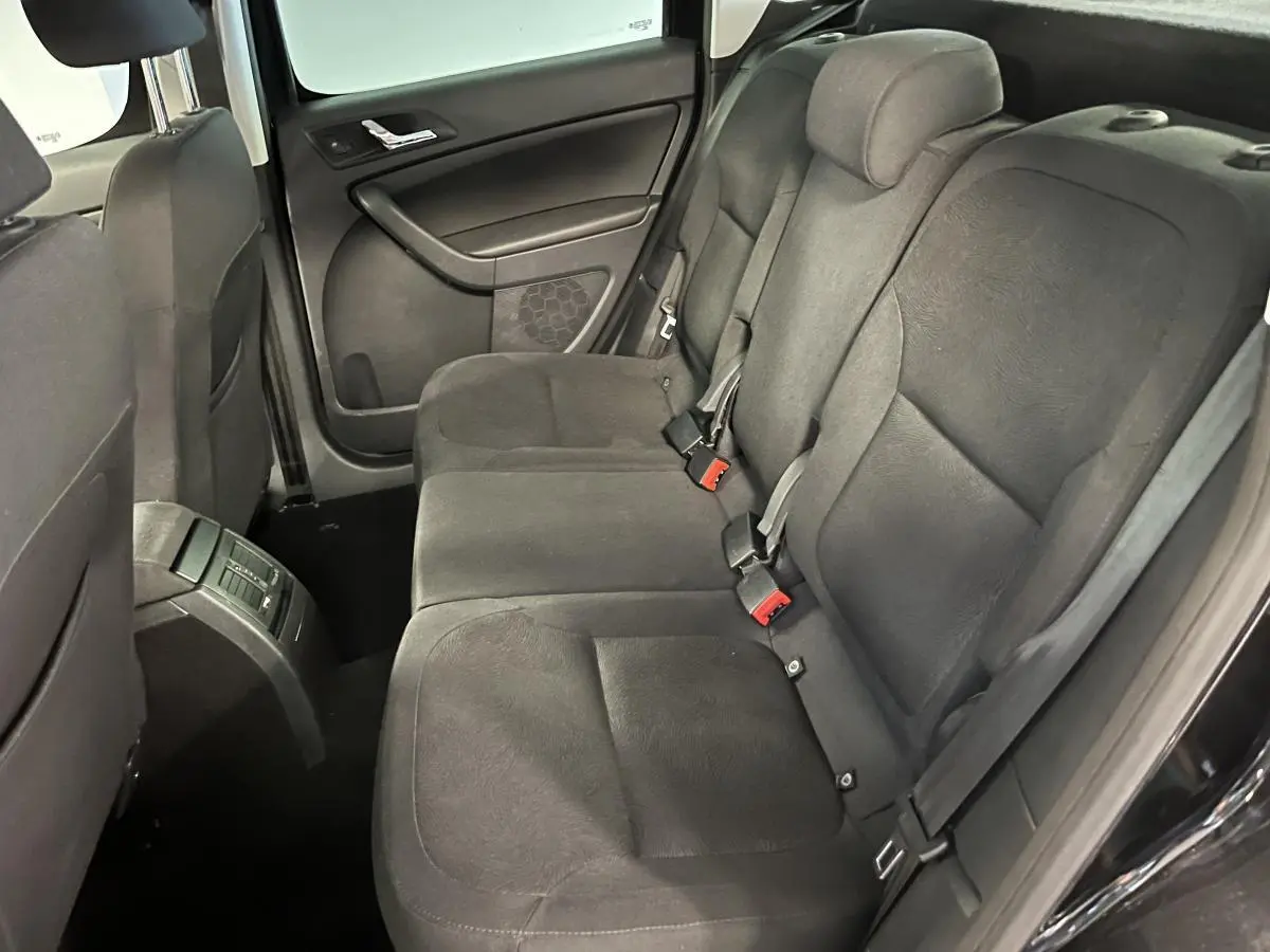 Vue intérieure côté droit des sièges arrière en tissu noir du Skoda Yeti 2015 avec ceintures et appuie-têtes intégrés.