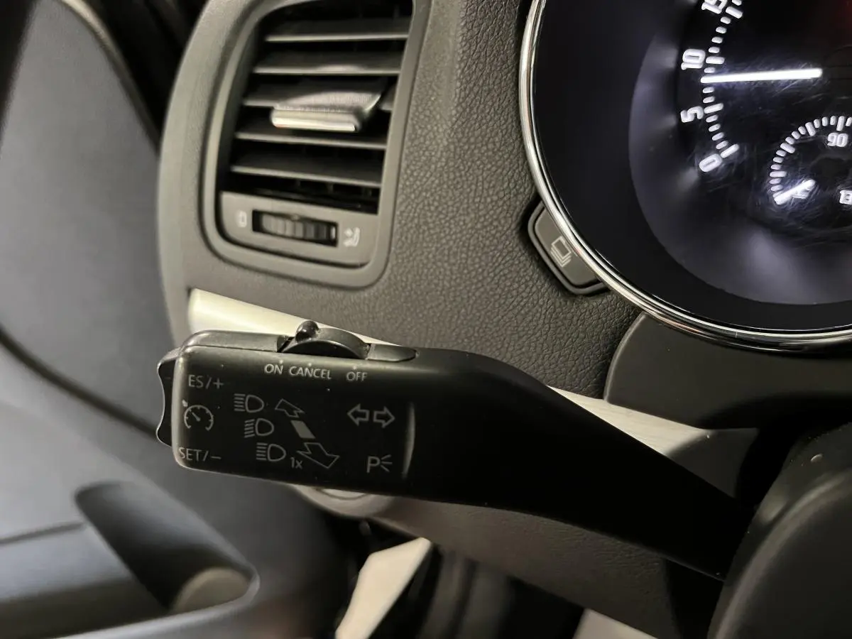 Gros plan sur la commande de régulateur de vitesse à gauche du tableau de bord noir du Skoda Yeti 2015.