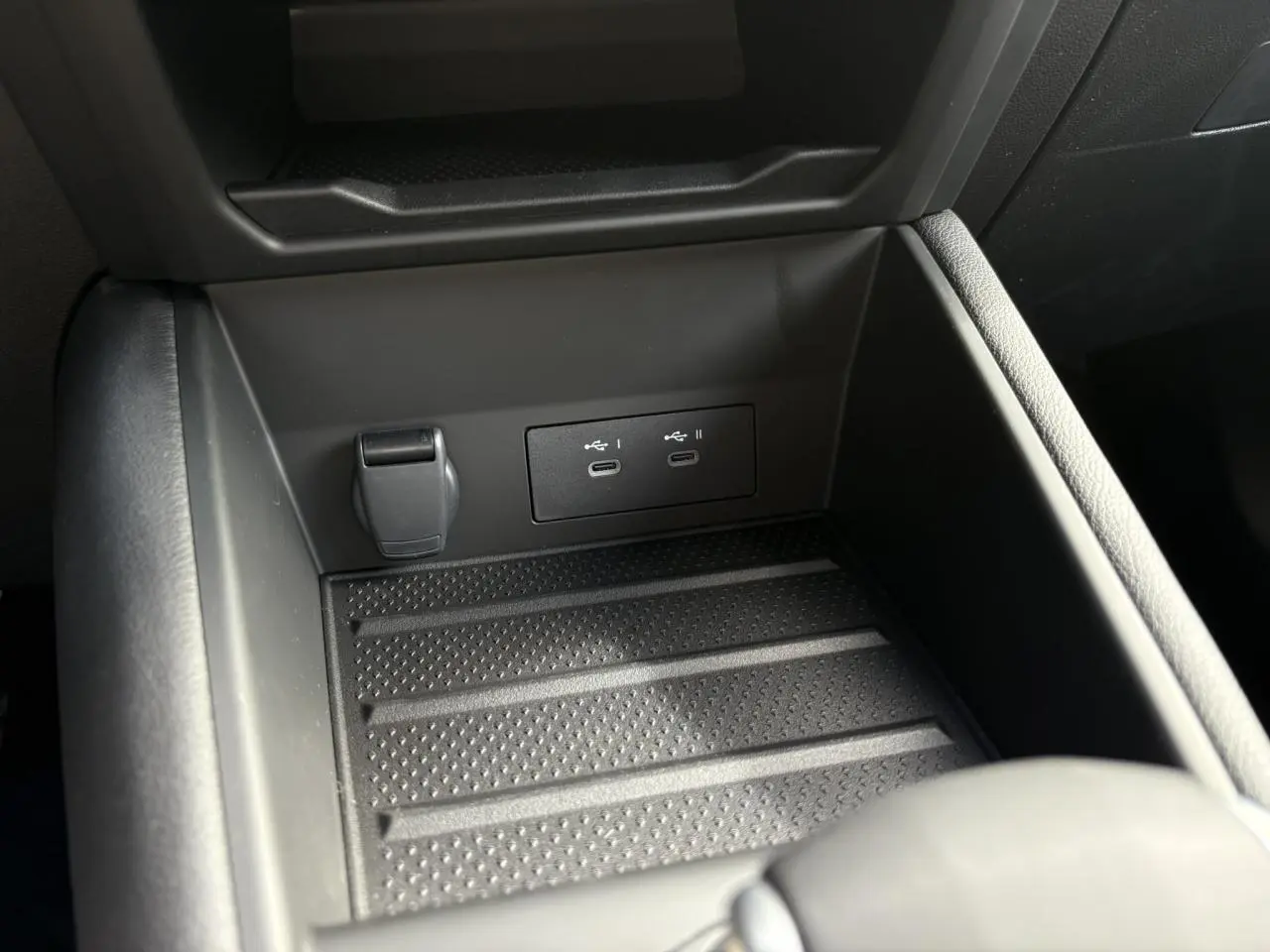 Rangement central ouvert avec prises USB-C et prise 12V dans l'habitacle de la Renault SYMBIOZ gris Rafale.