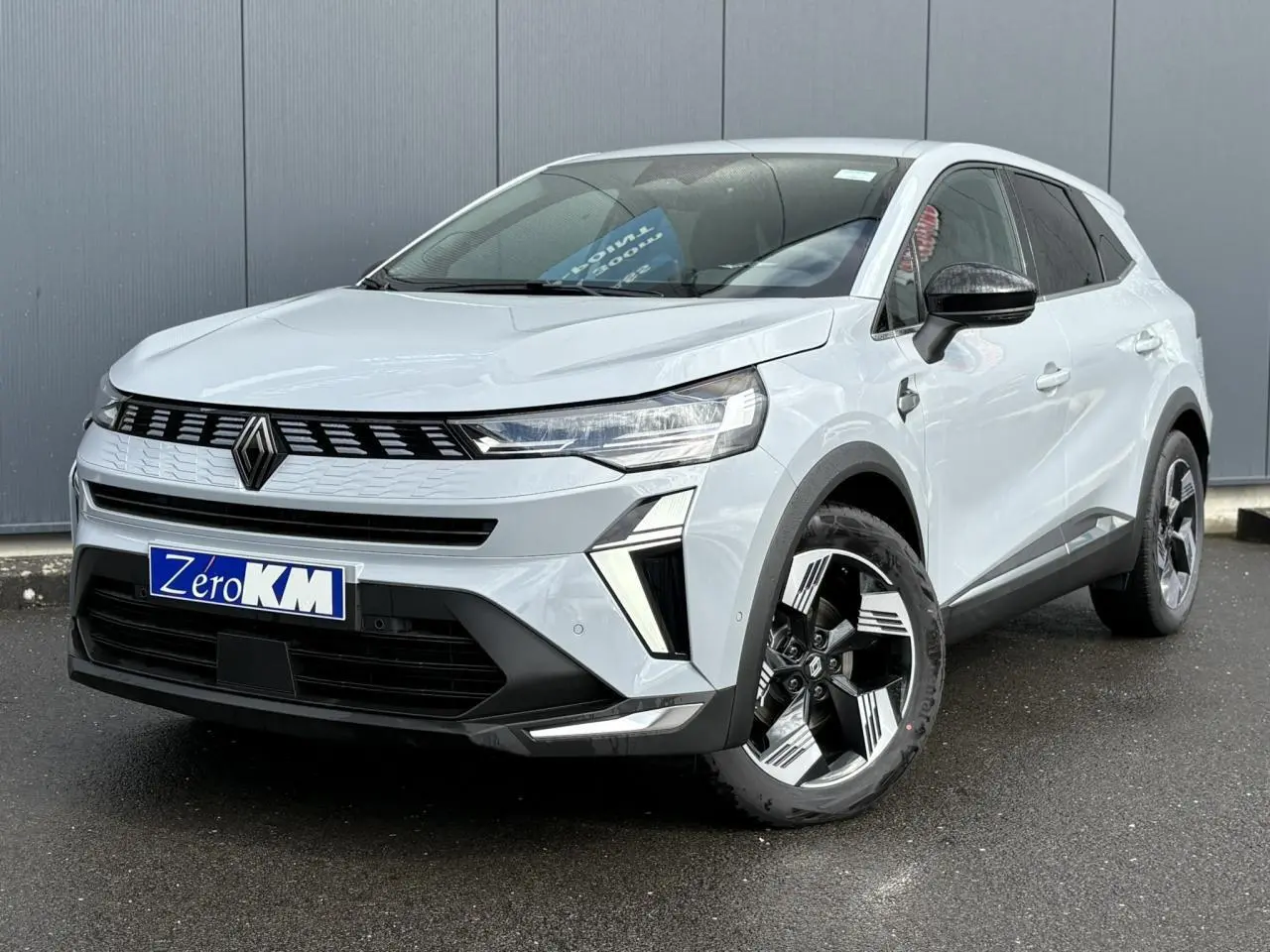 Renault Symbioz gris Rafale en 3/4 avant droit, avec calandre noire et jantes au design géométrique.