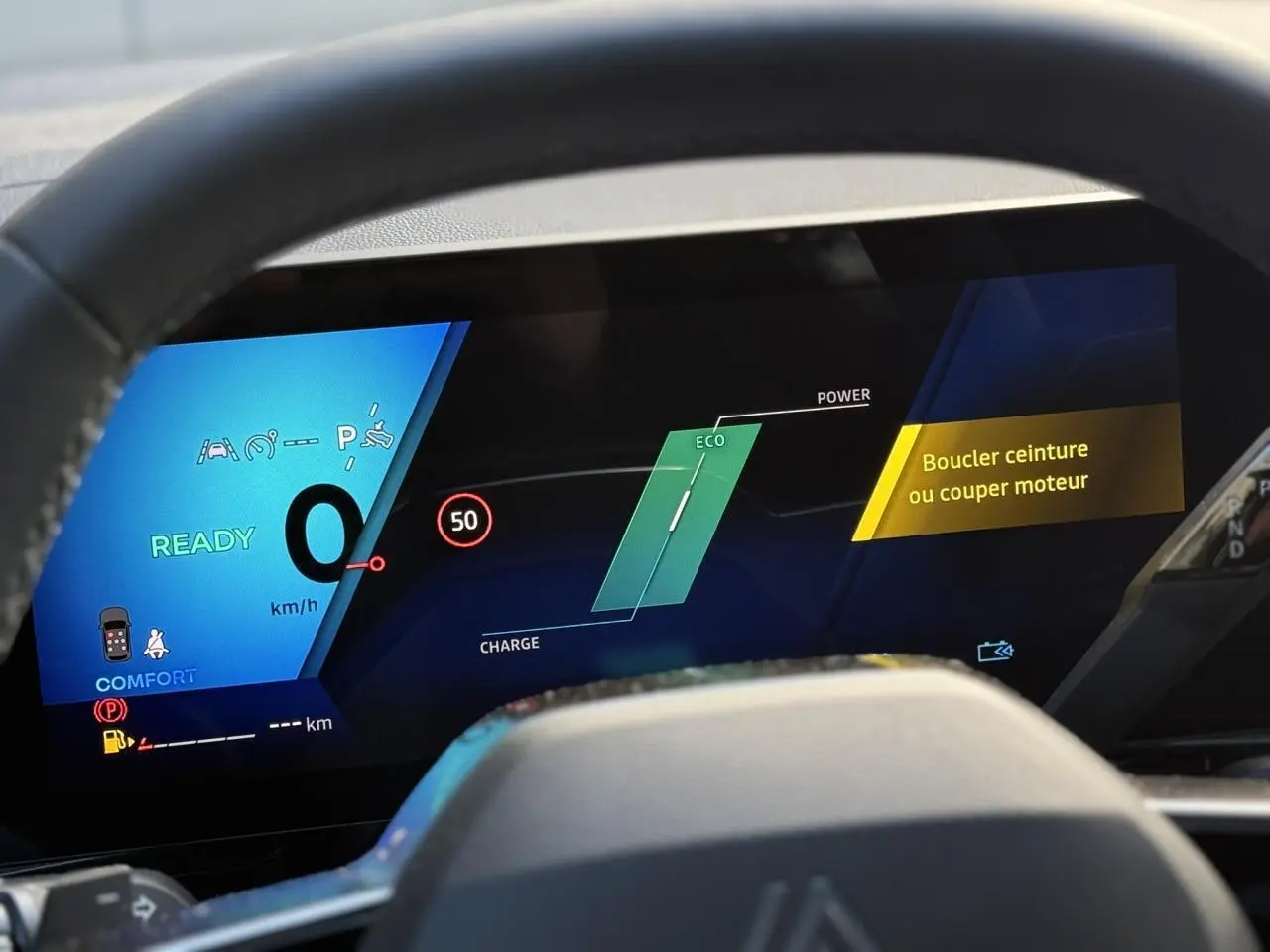 Tableau de bord numérique du Renault Espace VI hybride, affichant vitesse zéro et alertes de sécurité.