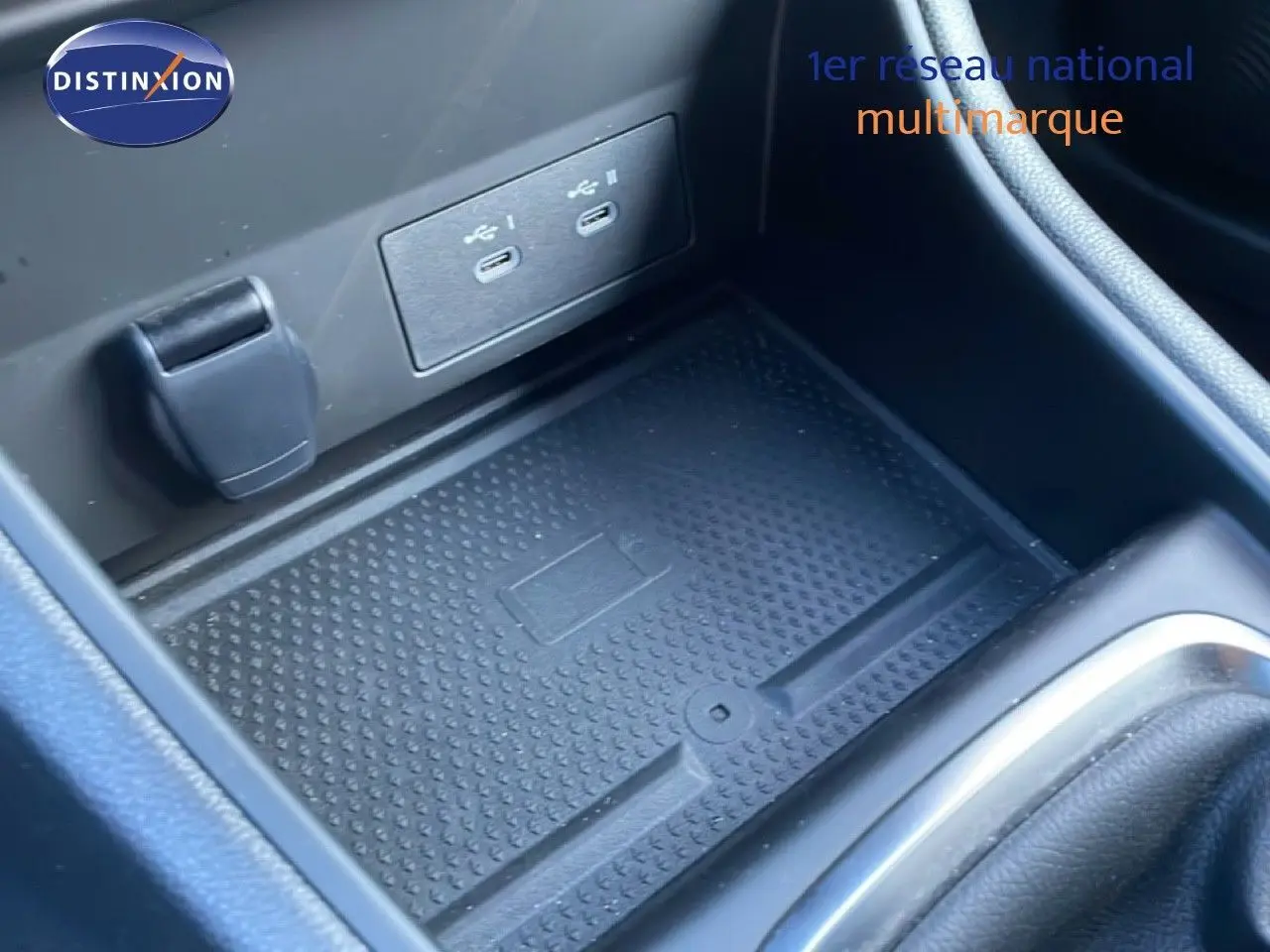 Gros plan sur la console centrale du Renault Captur 2025, montrant le chargeur sans fil et deux ports USB.