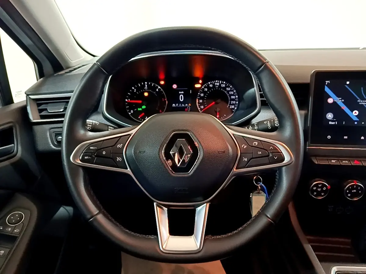 Vue frontale du volant cuir noir de la Renault Clio Business Blue dCi 85 avec tableau de bord et écran tactile allumé.