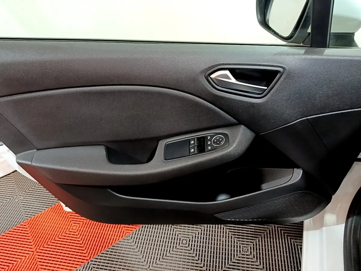 Intérieur côté conducteur de la Renault Clio Business blanc, montrant la portière avec commandes des vitres et rétroviseur.
