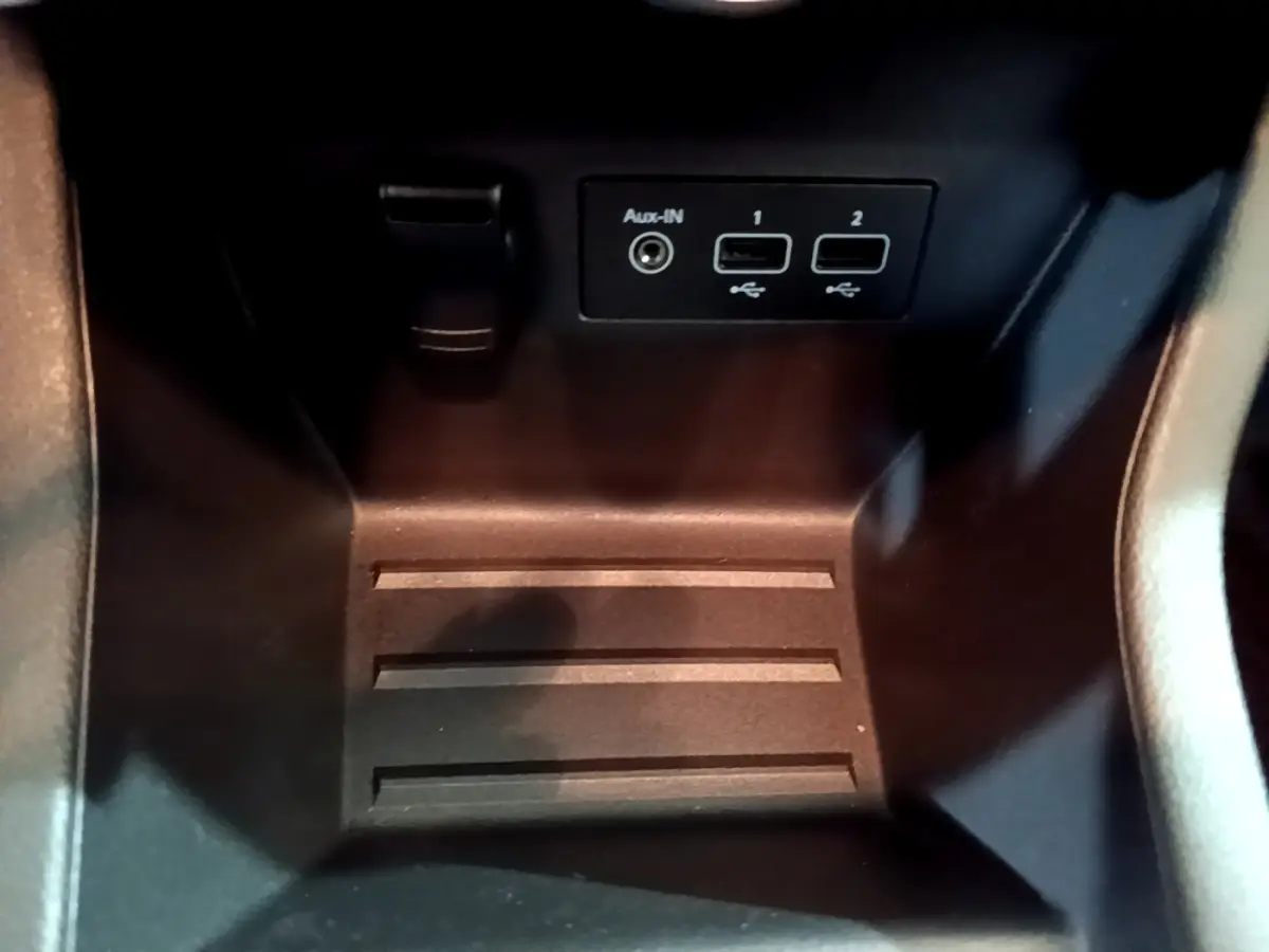 Gros plan sur la console centrale noire de la Renault Clio Business Blue dCi 85 avec prises USB et Aux-In visibles.