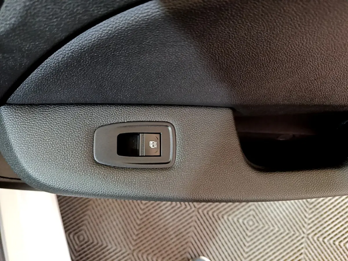 Bouton de verrouillage centralisé sur panneau de porte intérieure noire d'une Renault Clio Business Blue dCi 85 blanche.