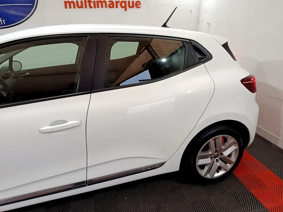 Profil côté gauche de la Renault Clio blanche 2020, mettant en valeur la ligne épurée et les jantes alliage.