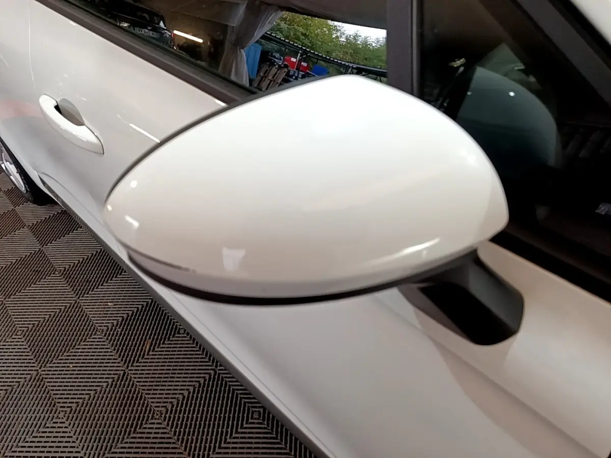 Rétroviseur blanc en gros plan côté gauche d'une Renault Clio Business Blue dCi 85 blanche, vue intérieure.