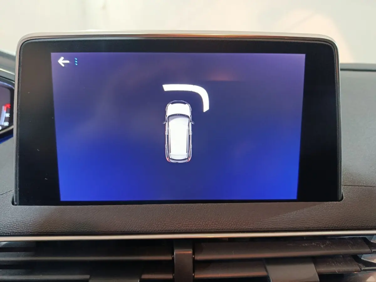 Écran tactile intérieur du Peugeot 3008 affichant la vue de dessus du véhicule avec indication de braquage.