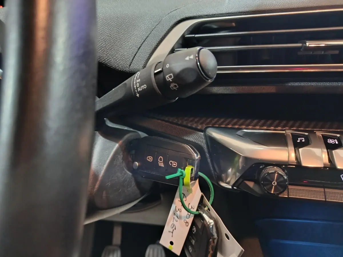 Gros plan sur la clé de contact insérée côté gauche du tableau de bord noir du Peugeot 3008 2020 diesel.