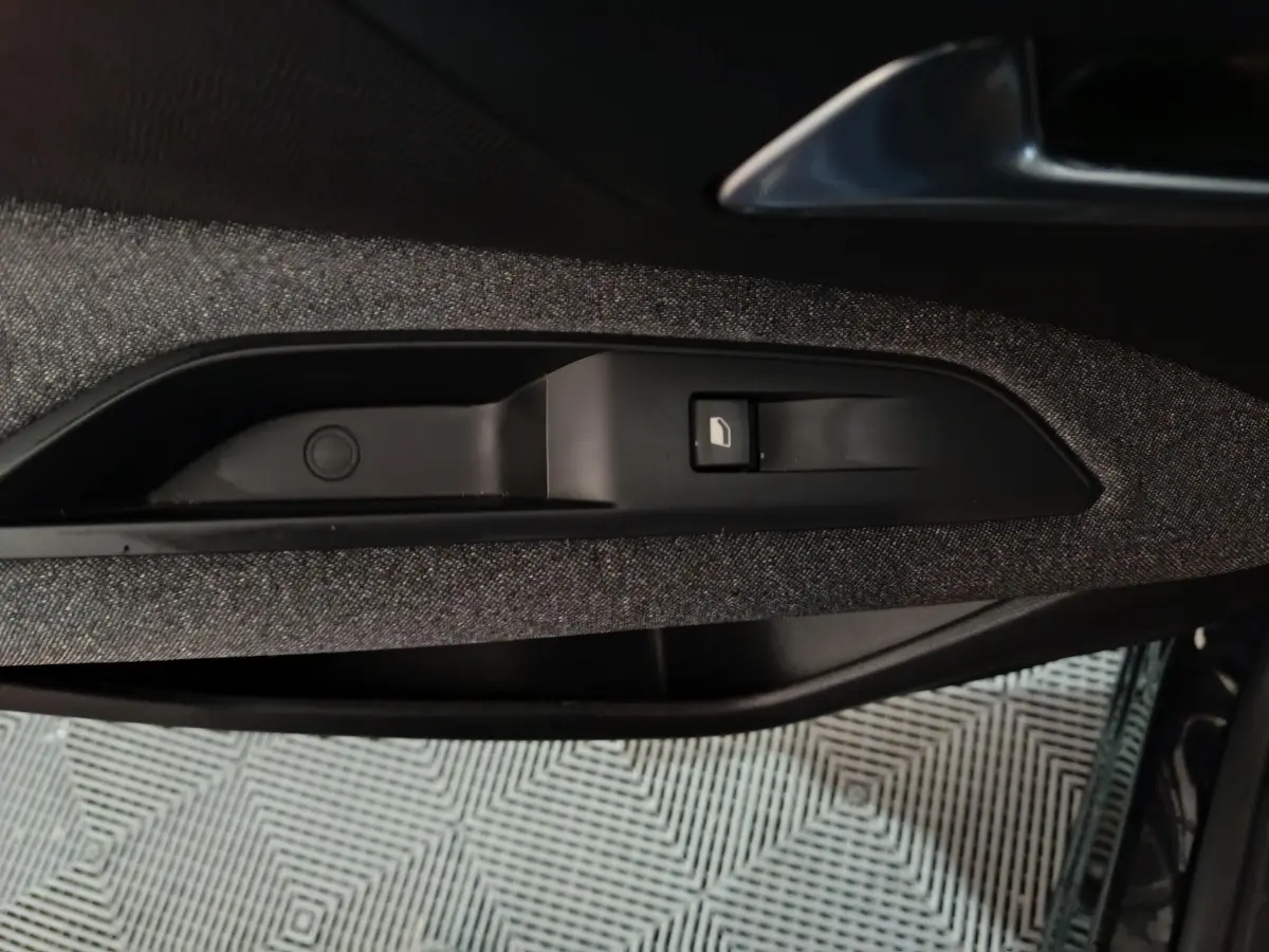 Gros plan sur la commande de verrouillage de porte côté gauche avec garniture tissu gris foncé dans un Peugeot 3008 2020.