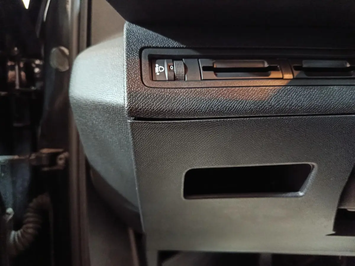 Détail du tableau de bord noir côté gauche avec commande de réglage des phares du Peugeot 3008 2020 BlueHDi.