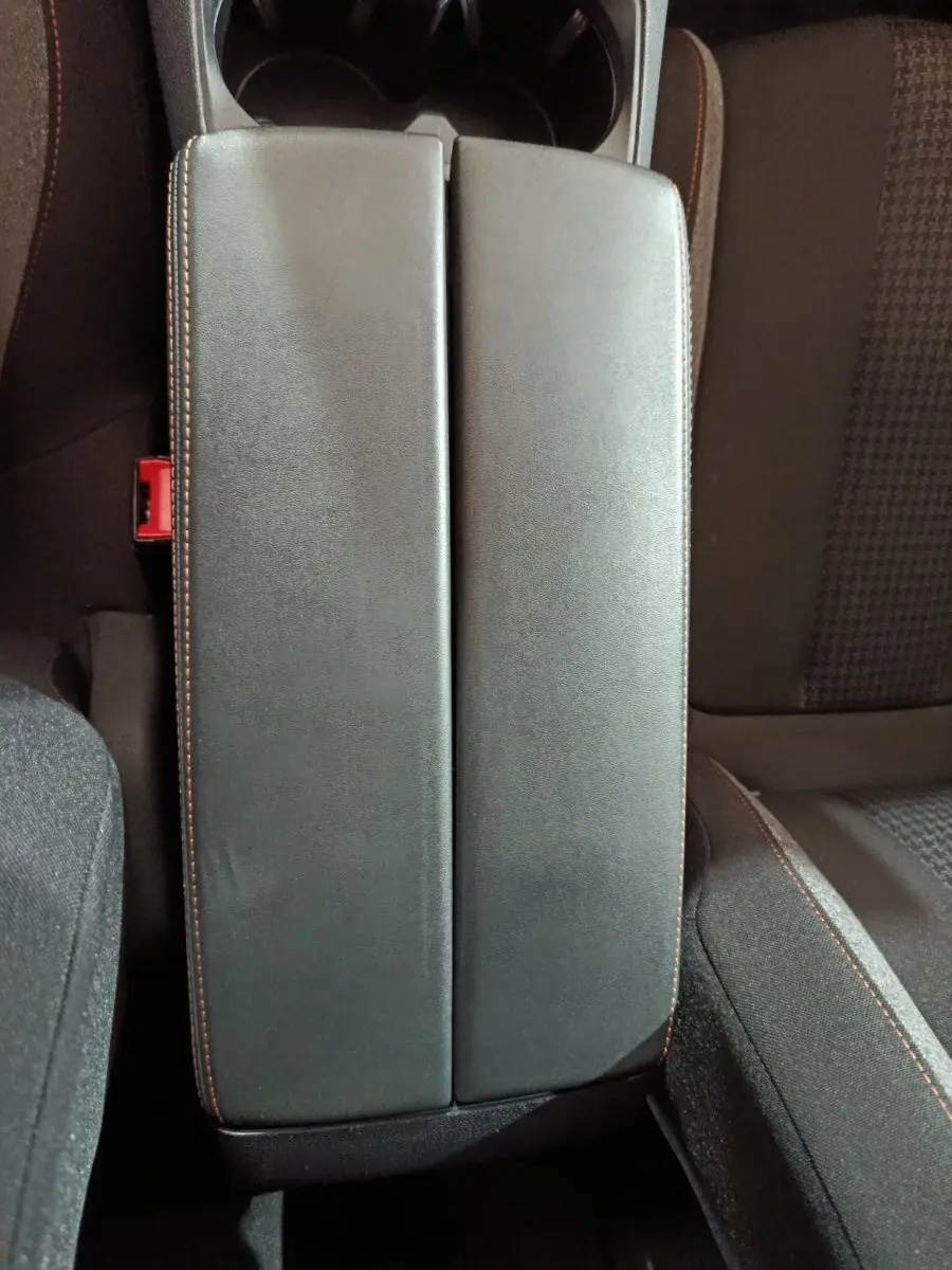 Accoudoir central noir avec surpiqûres orange entre les sièges avant du Peugeot 3008 2020 diesel.