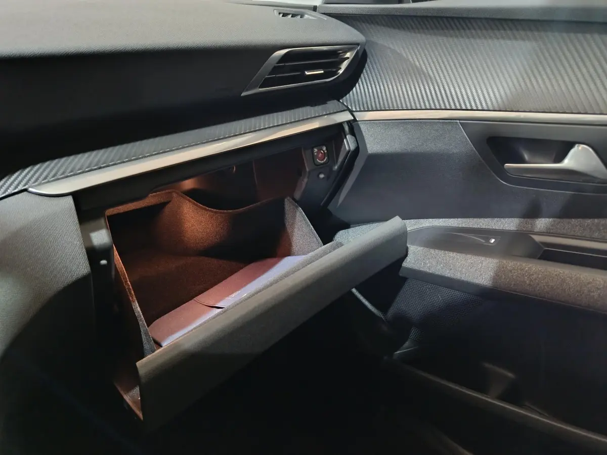 Vue intérieure côté passager du Peugeot 3008 2020 avec boîte à gants ouverte et tableau de bord noir texturé.