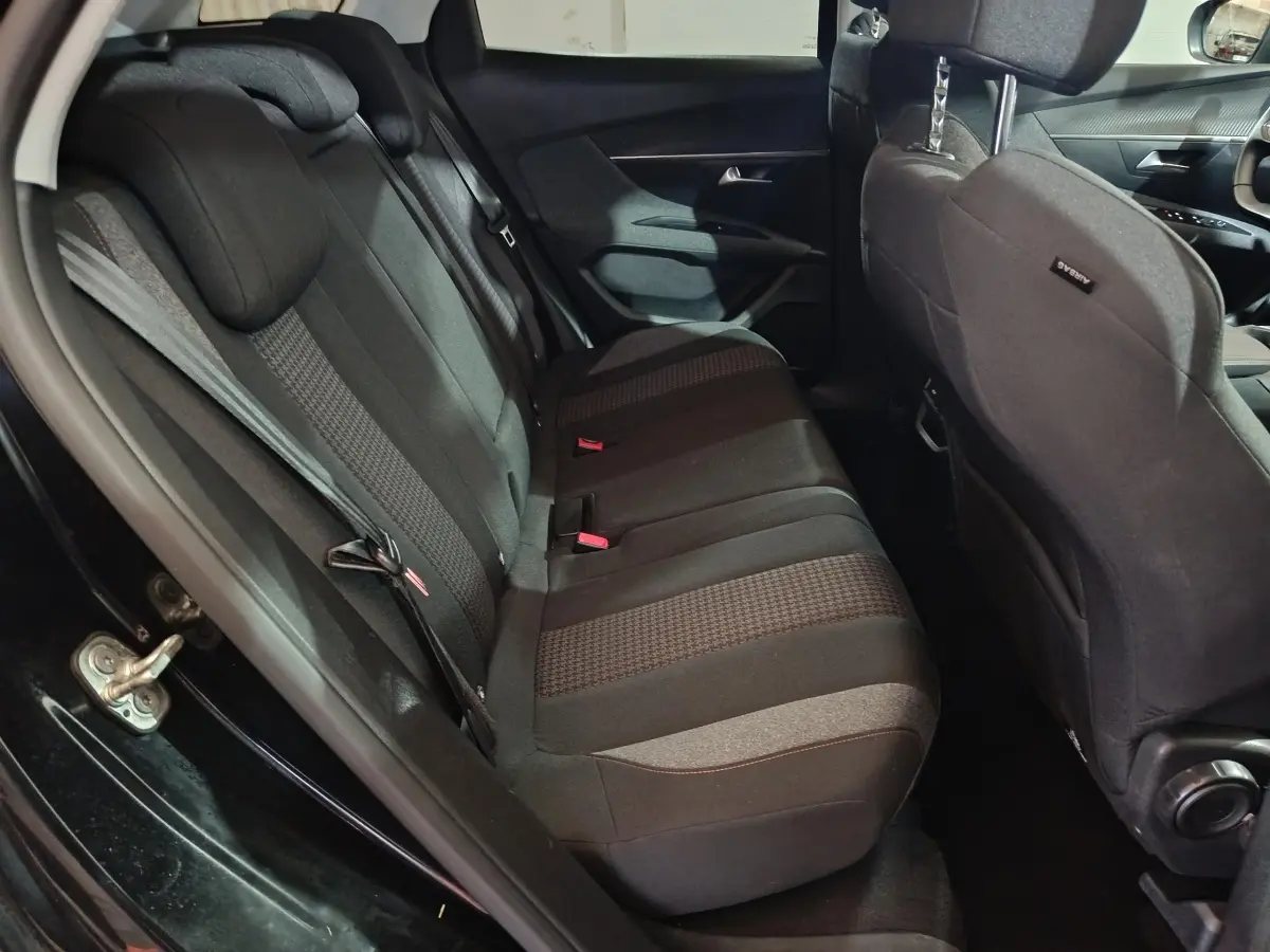 Vue côté gauche de la banquette arrière noire et grise du Peugeot 3008 2020 avec appuie-tête et ceintures visibles.