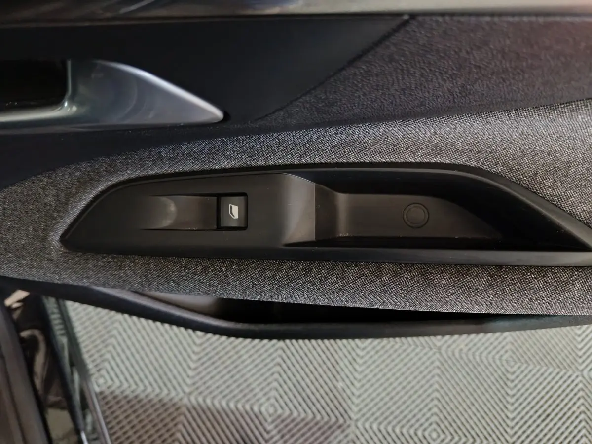 Gros plan sur la commande de lève-vitre côté gauche avec garniture tissu gris du Peugeot 3008 BlueHDi 130 2020.