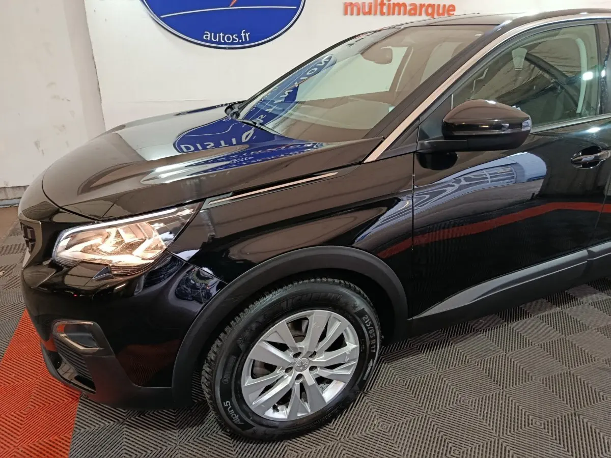 Peugeot 3008 noir en vue 3/4 avant droit, mettant en valeur ses phares allumés et jantes alliage.