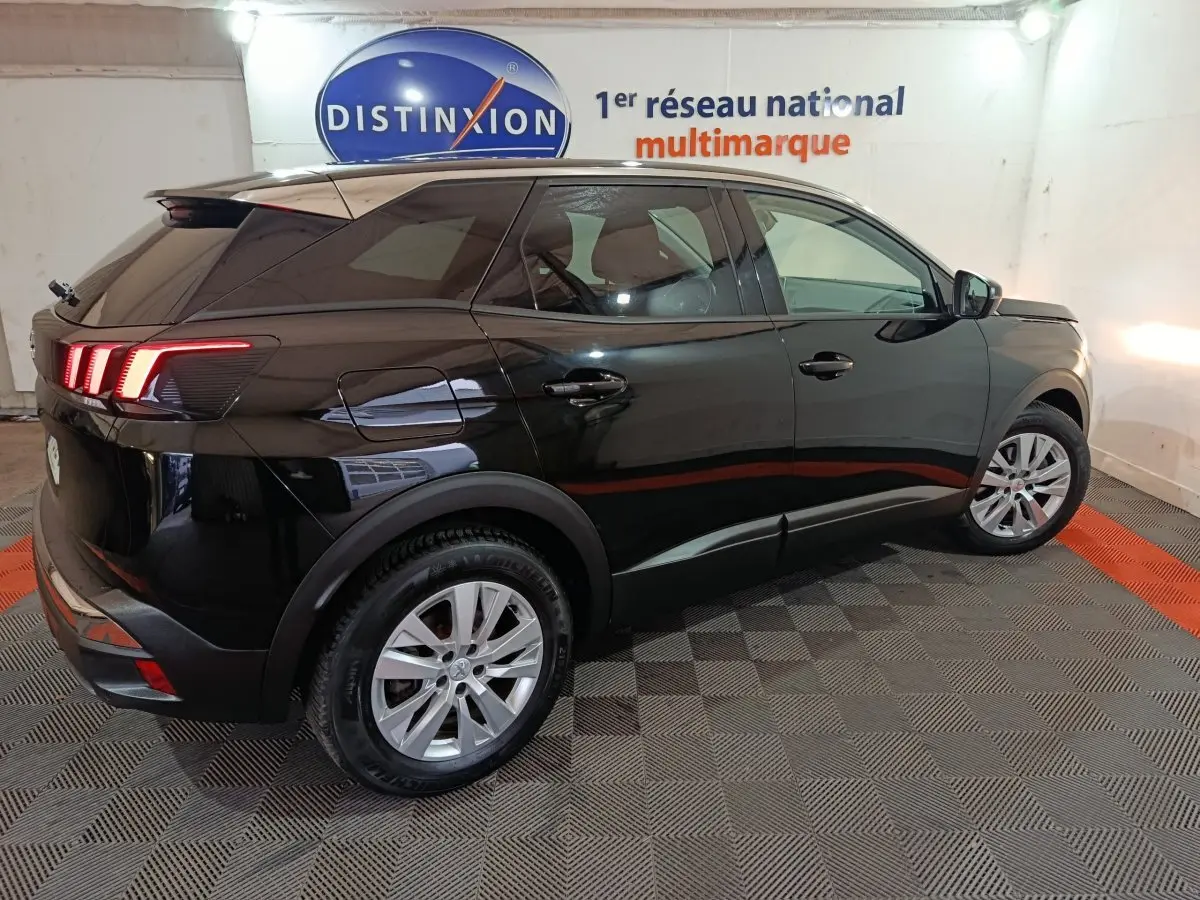 Peugeot 3008 noir vue de profil côté droit en intérieur, feux arrière allumés et jantes argentées visibles.