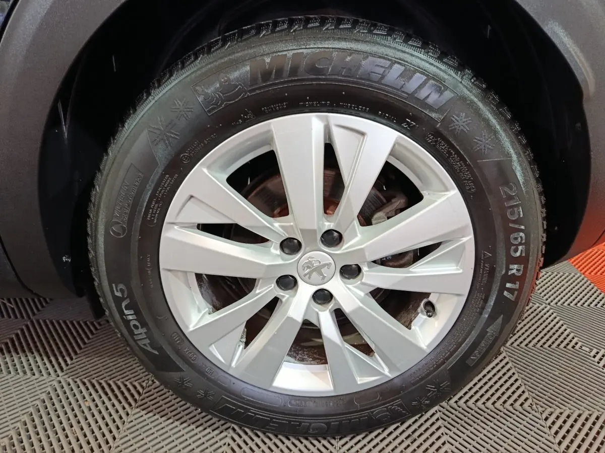 Gros plan sur la roue avant droite du Peugeot 3008 2020 avec jante argentée et pneu Michelin hiver Alpin 5