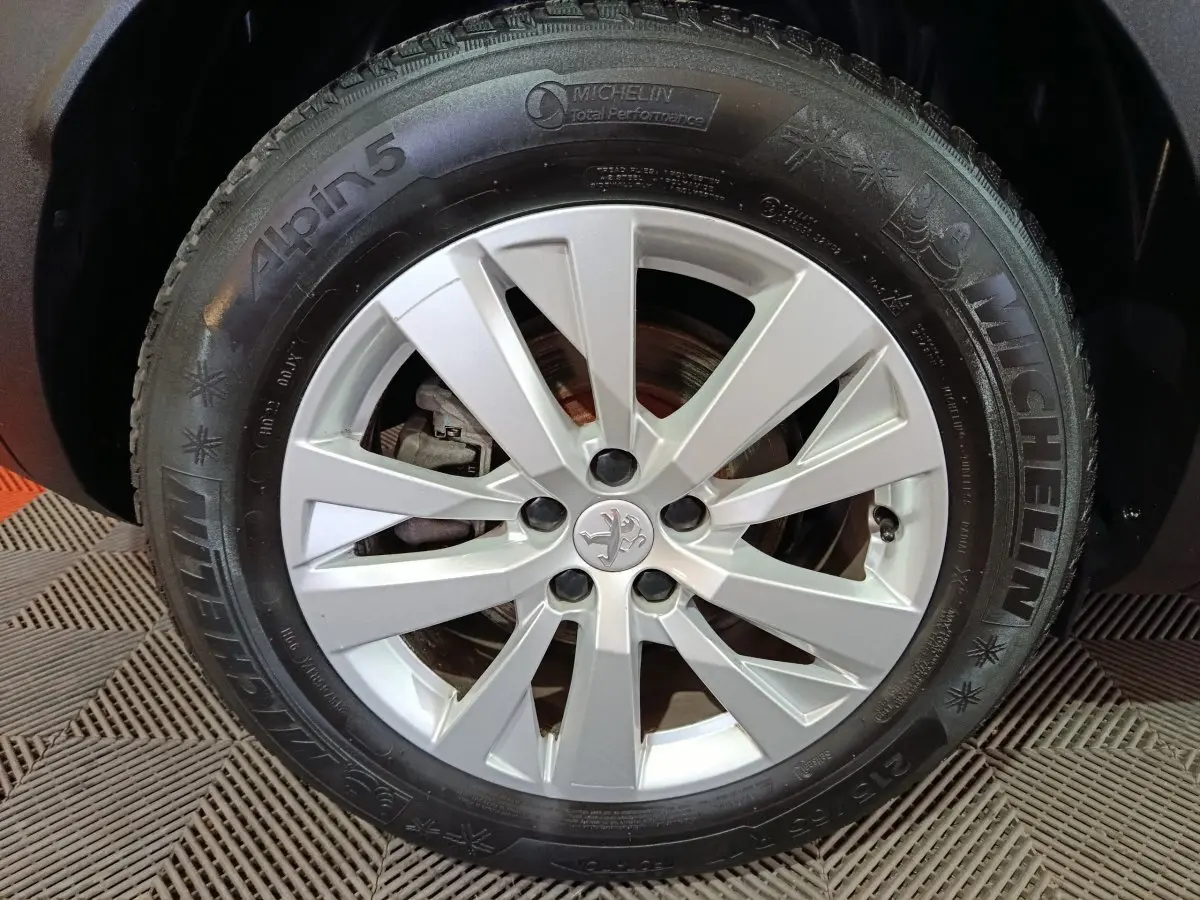 Gros plan sur la roue avant droite du Peugeot 3008 2020 avec jante argentée et pneu Michelin Alpin 5 hiver.