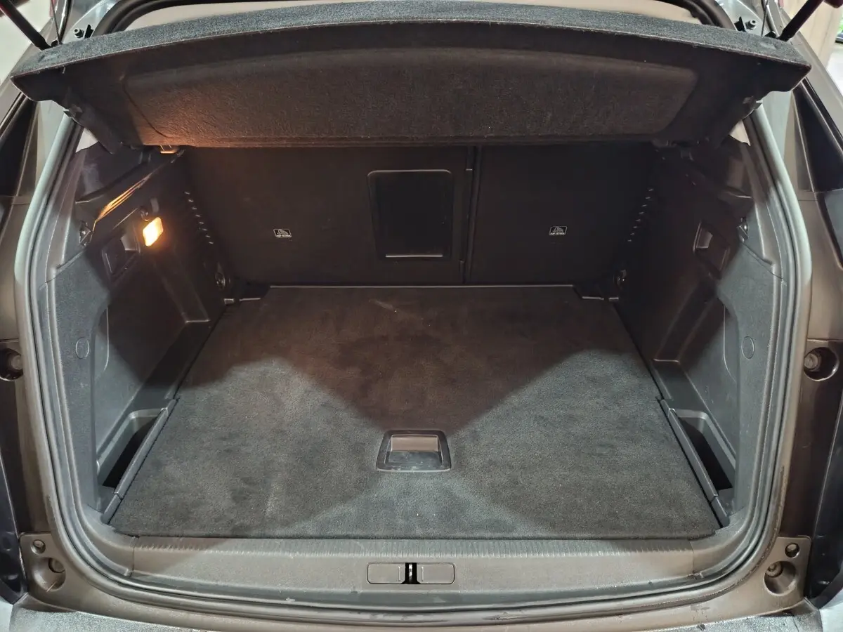 Coffre ouvert vu de l'arrière d'un Peugeot 3008 2020, intérieur noir avec éclairage latéral à gauche.