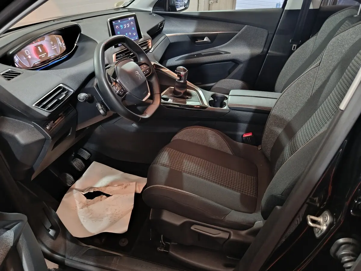 Intérieur avant droit du Peugeot 3008 2020 avec volant cuir, boîte manuelle et écran tactile central allumé.