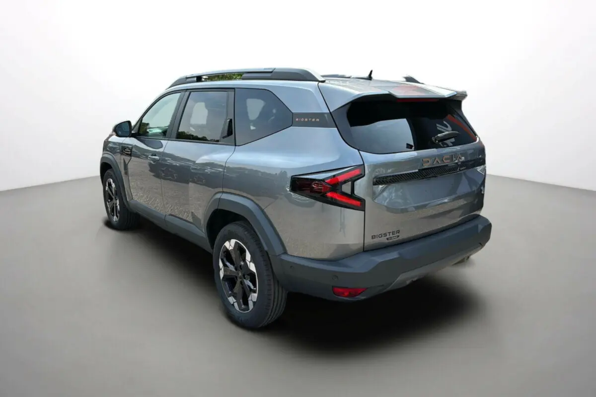 Vue 3/4 arrière droit du Dacia Bigster Hybrid 155 Extreme Plus gris schiste avec jantes alu 18 pouces et hayon électrique.