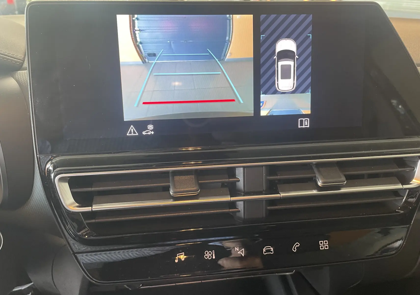 Écran tactile intérieur du Citroën C5 Aircross hybride 2025 affichant la caméra de recul et la vue 360°, avec tableau de bord noir brillant.