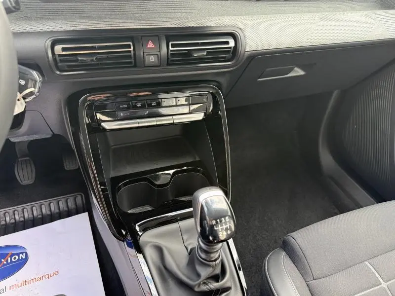 Vue intérieure centrée sur la console centrale et levier de vitesse manuel de la Citroën C3 gris Mercury 2025.