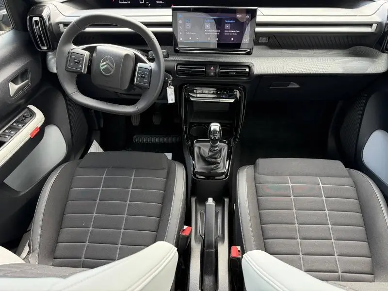 Vue intérieure frontale de la Citroën C3 1.2 Turbo 2025 en gris Mercury, avec volant multifonction et boîte manuelle.