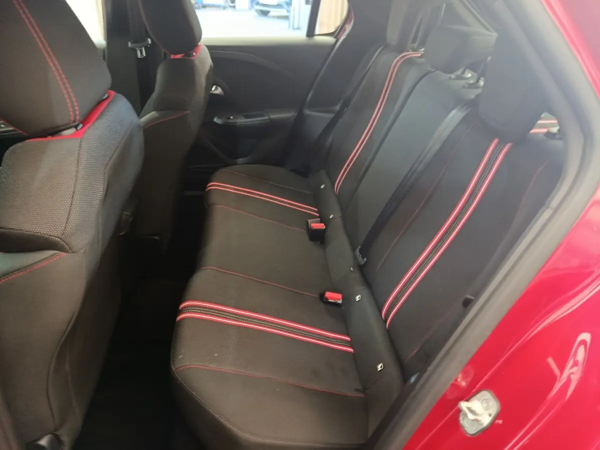 Vue intérieure côté arrière droit de l’Opel Corsa rouge 2023, banquette noire avec surpiqûres rouges visibles.