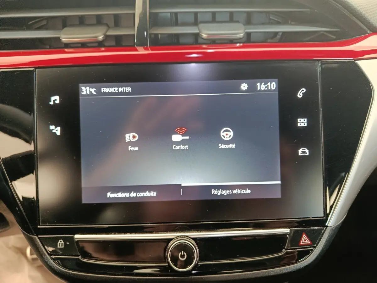Écran tactile central de 10 pouces de l’Opel Corsa rouge 2023 affichant les réglages véhicule et fonctions de conduite.
