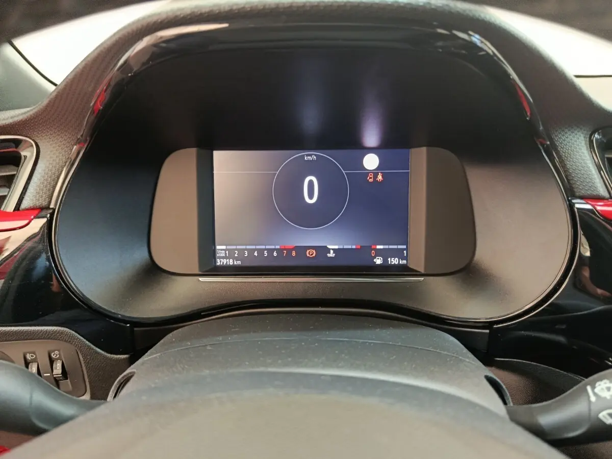 Vue rapprochée du combiné d'instruments numérique de l'Opel Corsa rouge 2023, affichant la vitesse à 0 km/h.